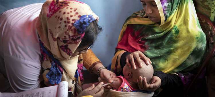 UNICEF/Brown Una voluntaria vacunando a un beb en un centro de atencin primaria de uno de los vastos campamentos de refugiados de Coxs Bazaar, Bangladesh